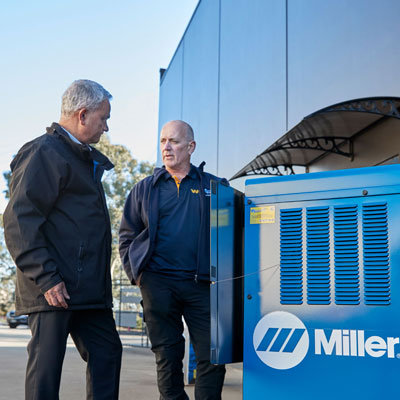 2 guys standing around a welding machine